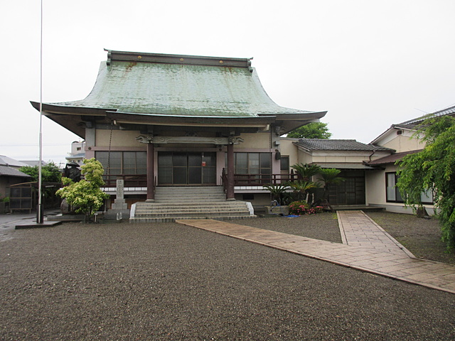 雨に濡れるお寺の本堂境内